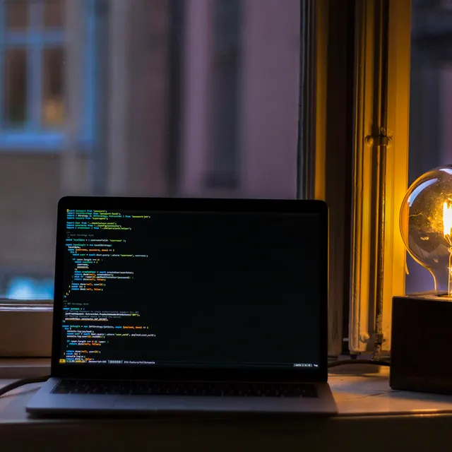 Laptop menyala menampilkan kode program
